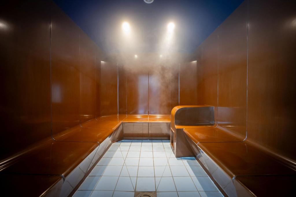 a small bathroom with a bench and a toilet at Résidence Prestige Odalys Le Domaine des Pins in Noirmoutier-en-l'lle