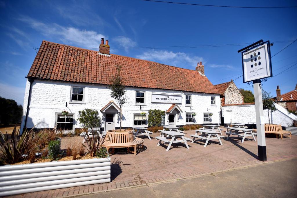 a white building with tables and chairs in front of it at Thornham Rooms at The Chequers in Thornham