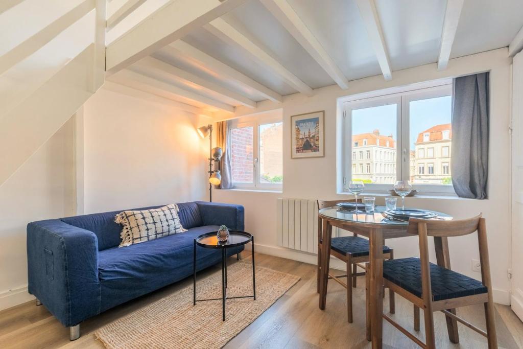 un salon avec un canapé bleu et une table dans l'établissement Joli studio à deux pas de l'Université Catholique, à Lille