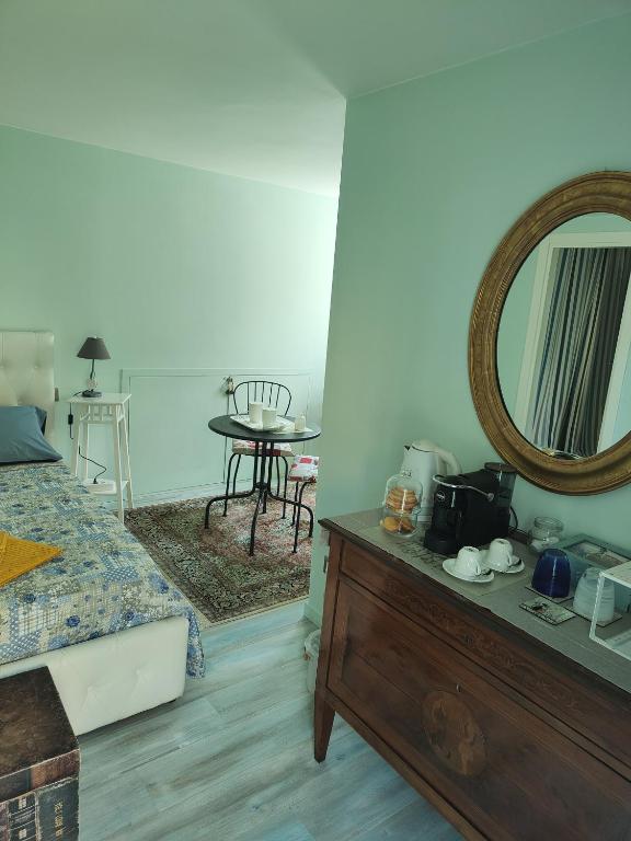 a bedroom with a bed and a mirror on a dresser at La Casa della Rosa Nana in Trezzano sul Naviglio