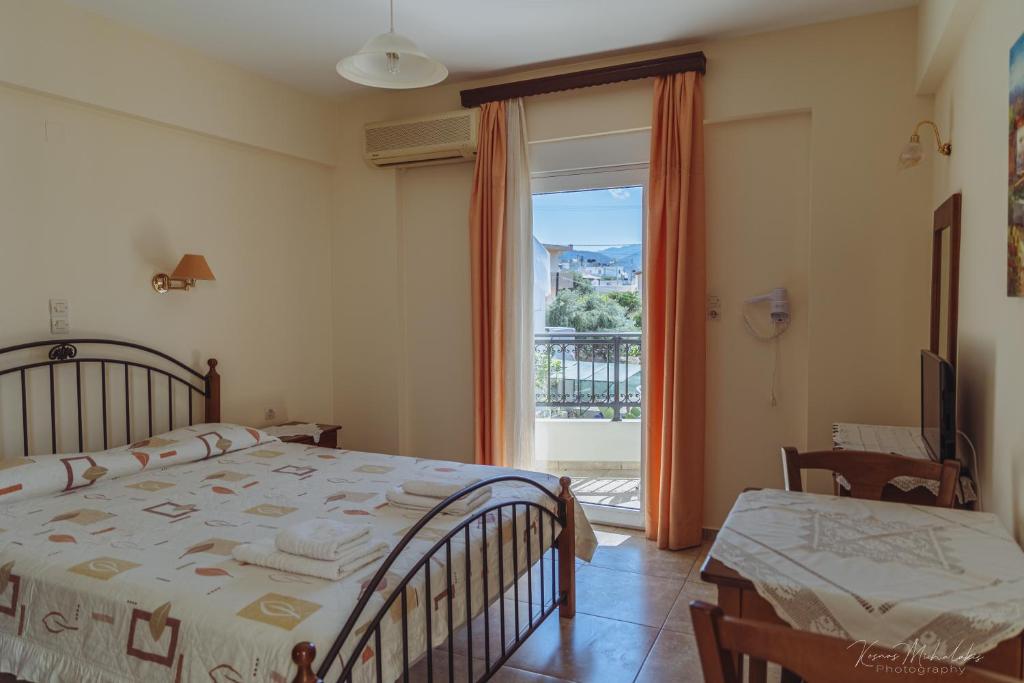 a bedroom with a bed and a large window at Vrokastro Apartments in Istro