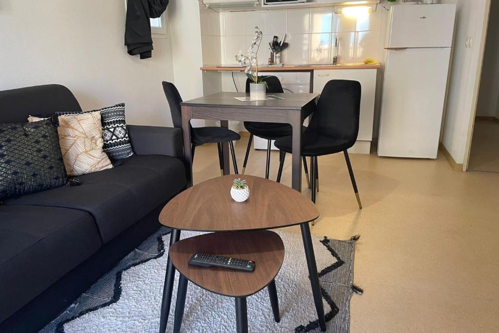 un salon avec un canapé, une table et des chaises dans l'établissement F24 Les Naïades- 1 bedroom for 4 people !, à Avène