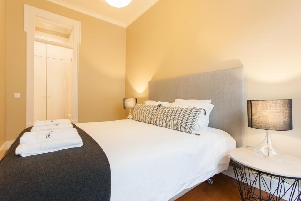 a bedroom with a large white bed and a lamp at FLH Baixa Blue Apartment in Lisbon
