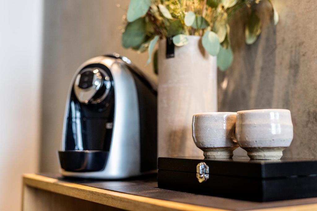 a coffee maker and two cups on a table at Aalborg Airport Hotel in Aalborg