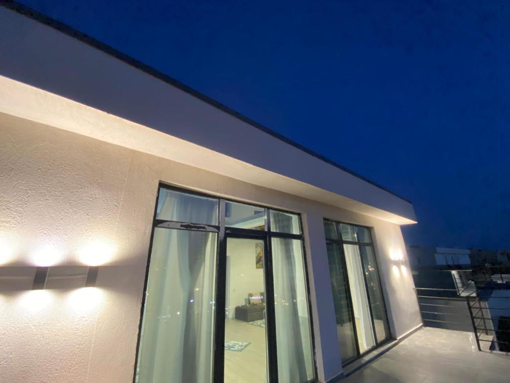 a white building with glass windows at night at Gut Aydin in Mamaia Nord