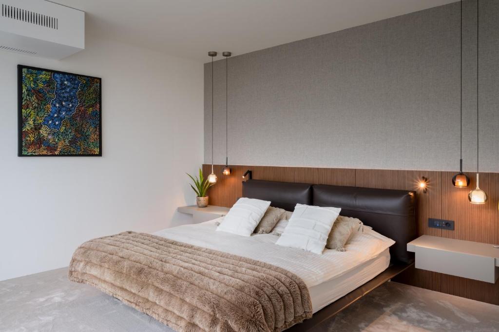 a bedroom with a large bed with a black headboard at Castle View Penthouse in Ljubljana