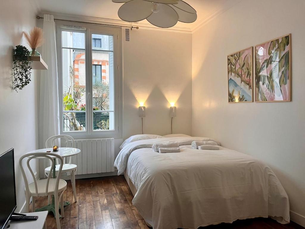 une chambre avec deux lits et une table et une fenêtre dans l'établissement Bright studio on garden, à Paris