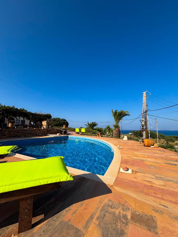 a swimming pool with a green cushion next to at Tethys Apartments Karfas in Chios