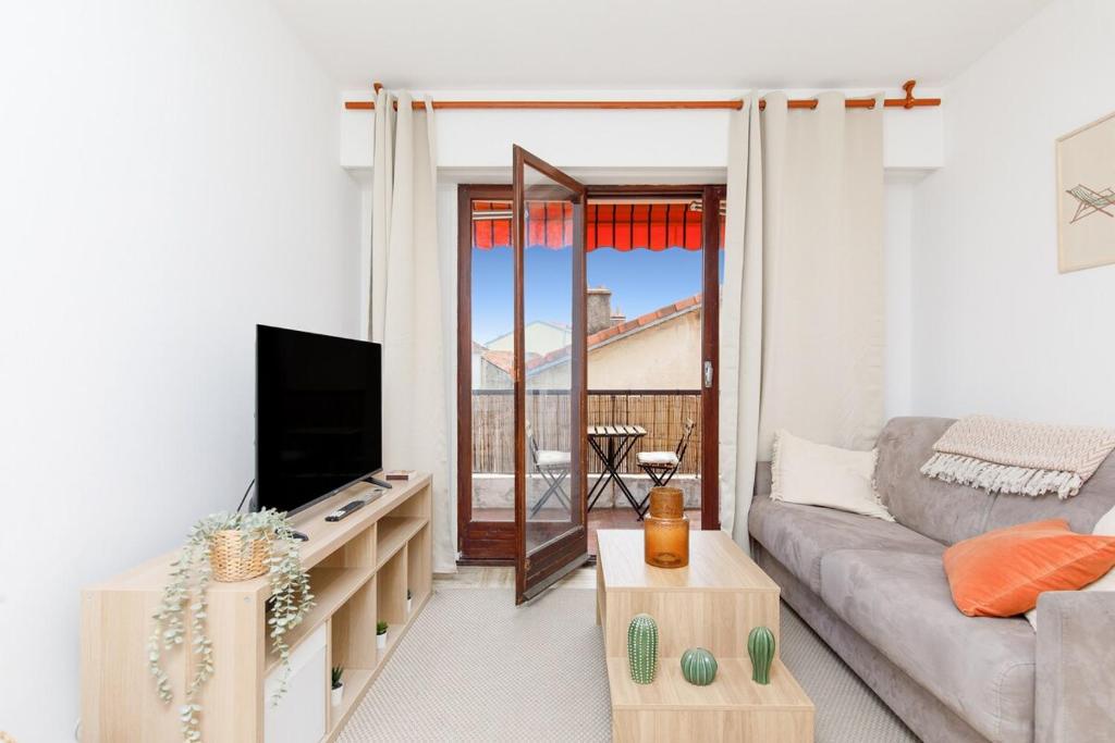 un salon avec un canapé et une télévision dans l'établissement Nice Flat with terrace & parking near city center, à Cannes