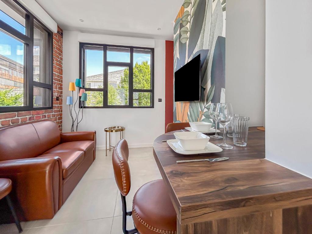 un salon avec une table et un canapé dans l'établissement 101 appartement 1 chambre Cosy et Lumineux, à Grenoble