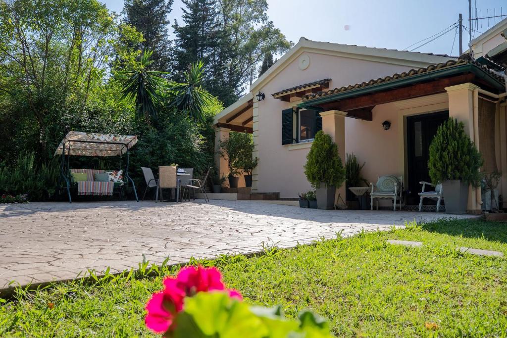 een huis met een tuin en een patio bij Arilia Country Cottage in Danilia