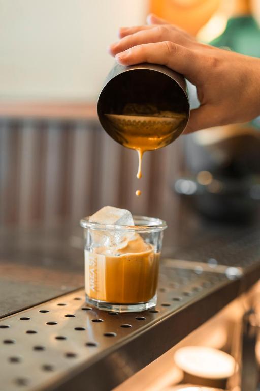 a person pouring honey into a cup of food at ON Residence - Small Luxury Hotels of the World in Thessaloniki