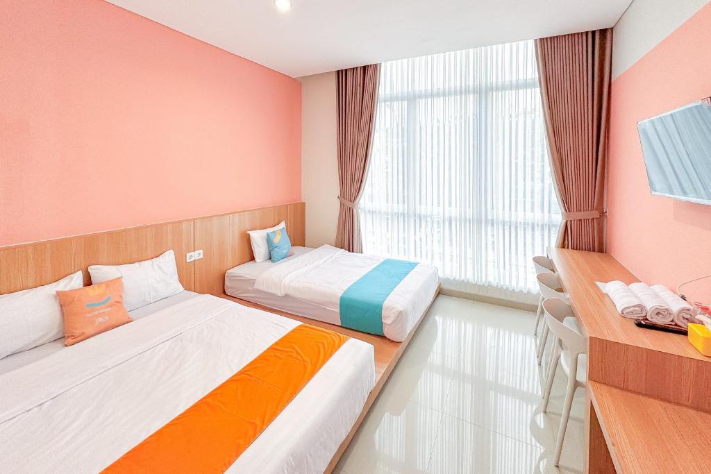 a hotel room with two beds and a window at SANS Stay Nagomi Home Semarang in Alastuwo