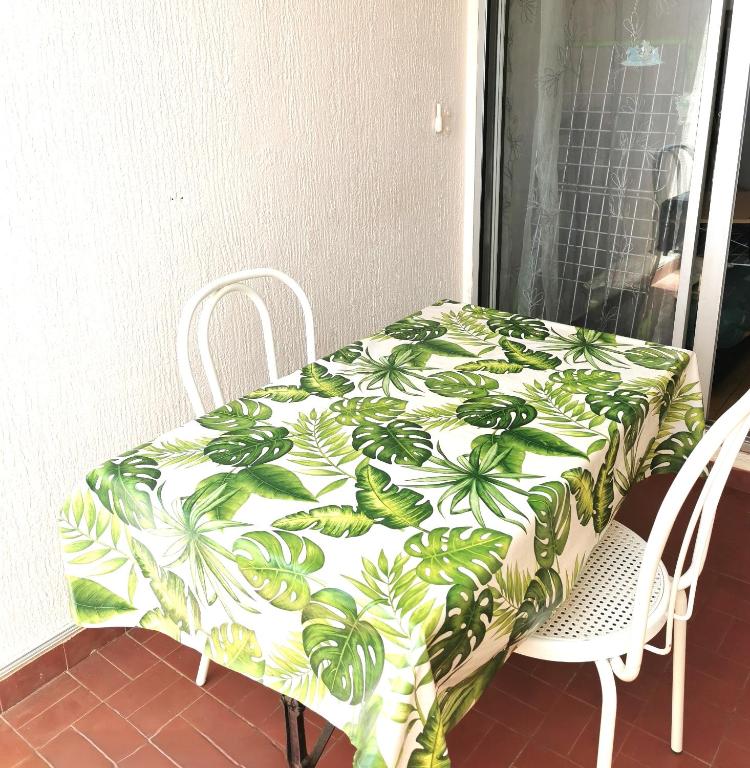 une table avec une couverture verte et blanche dessus dans l'établissement CAP D'AGDE Studio 3 personnes Résidence Sentosa B22 quartier môle, au Cap d'Agde