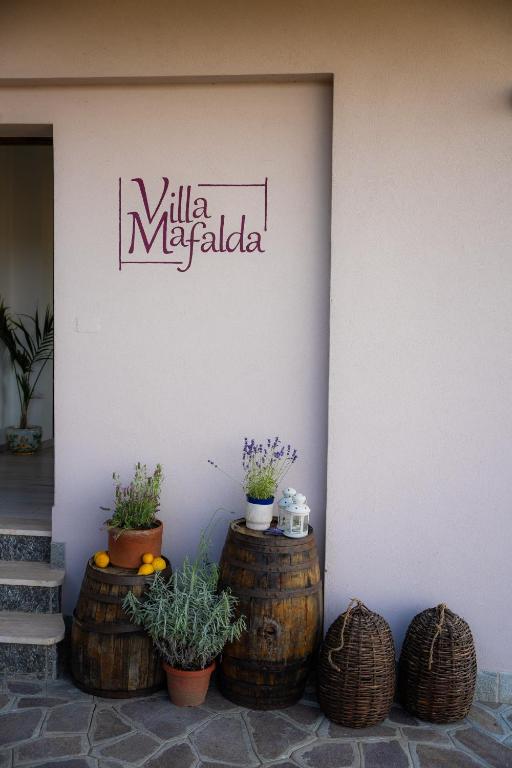 a sign on the side of a building with plants at Villa Mafalda in Pietra Ligure