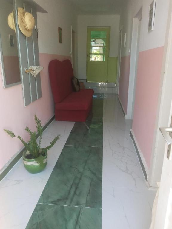 a living room with a red chair and a plant at Alanis in Vela Luka