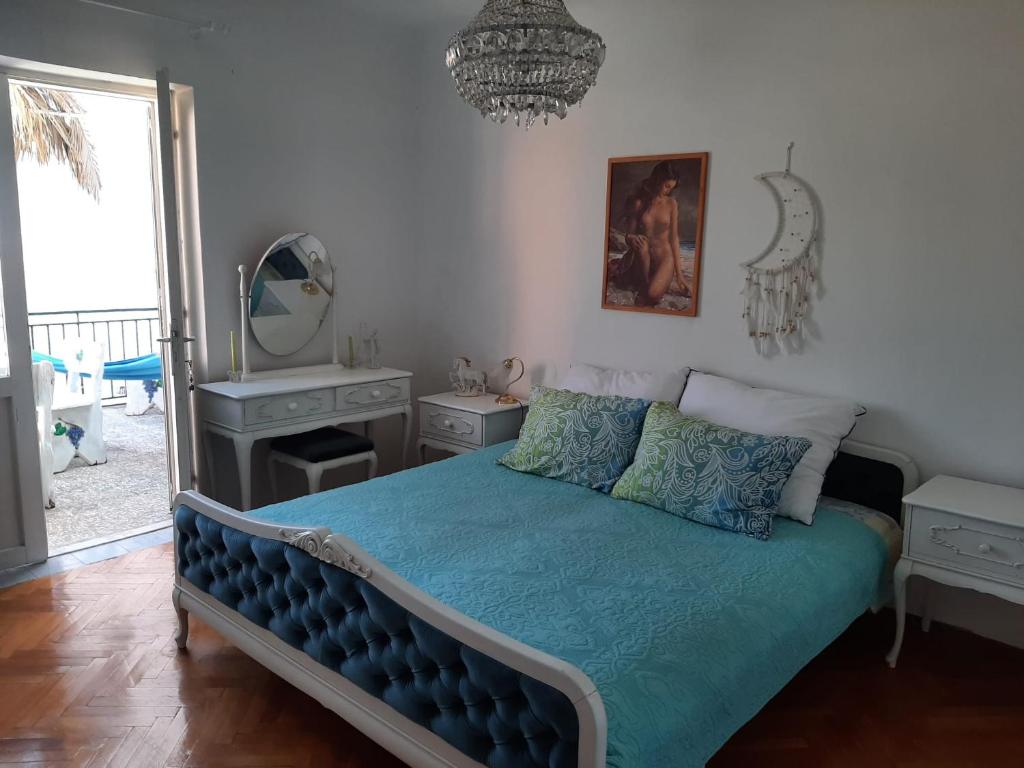 una camera da letto con un letto con un piumone blu e uno specchio di Alanis a Vela Luka (Vallegrande)