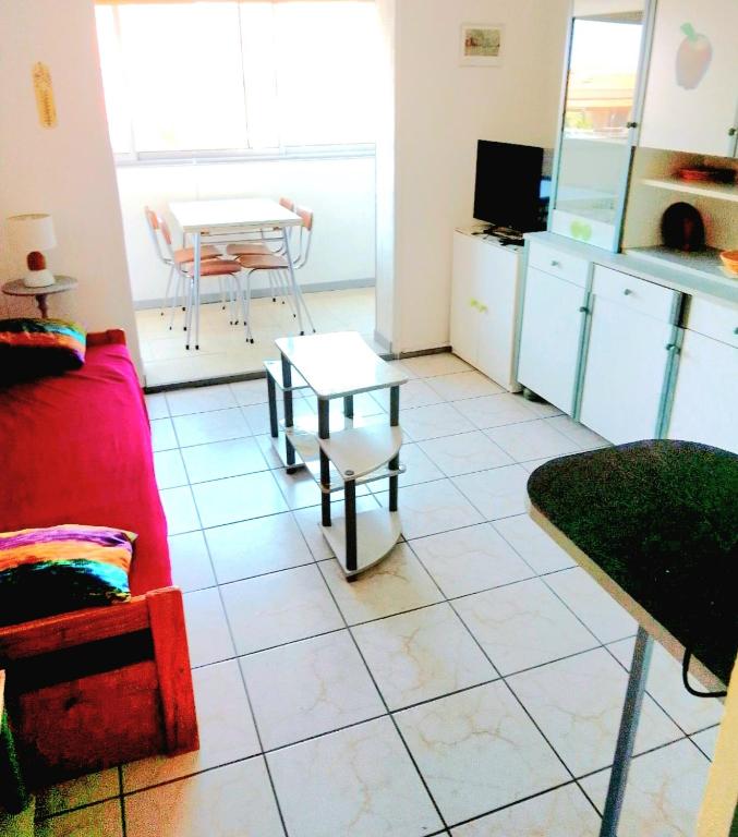 un salon avec un canapé rouge et une table dans l'établissement Mimi, à Port-la-Nouvelle