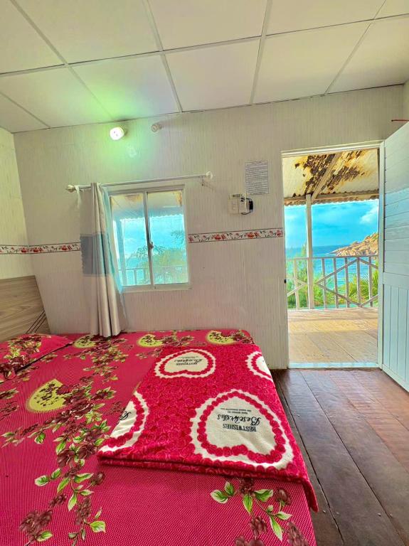 ein Schlafzimmer mit einem Bett mit einer roten Decke in der Unterkunft Đảo Bình Ba, Khách sạn view biển, tầng cao, không nhận khách quốc tế, phòng giường đôi, nhận cọc mới giữ phòng in Ấp Binh Ba