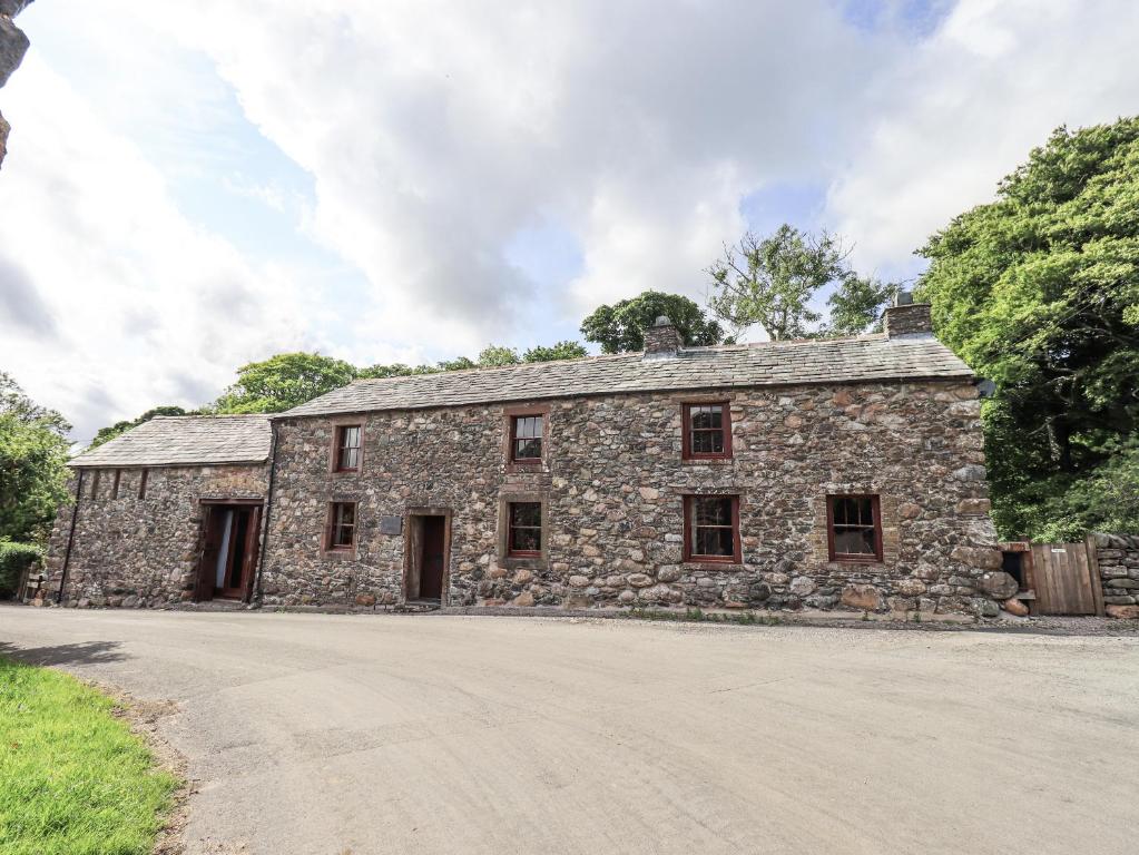 an old stone building on a dirt road at Chapel Cottage in Cleator