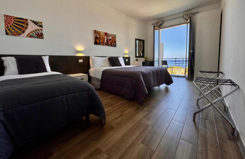 pokój hotelowy z 2 łóżkami i dużym oknem w obiekcie Bed and Breakfast Stella del Sud Makari w mieście Macari