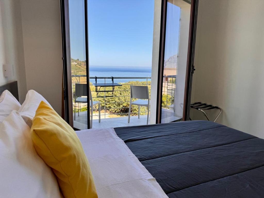 sypialnia z łóżkiem i widokiem na ocean w obiekcie Bed and Breakfast Stella del Sud Makari w mieście Macari