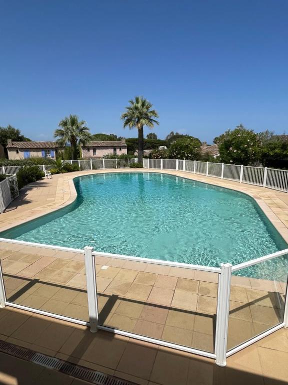 une grande piscine entourée d'une clôture. dans l'établissement L'escapade, à Saint-Tropez