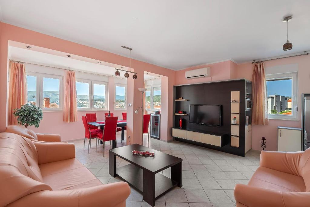 a living room with a couch and a tv and a table at Summer Memories in Okrug Gornji