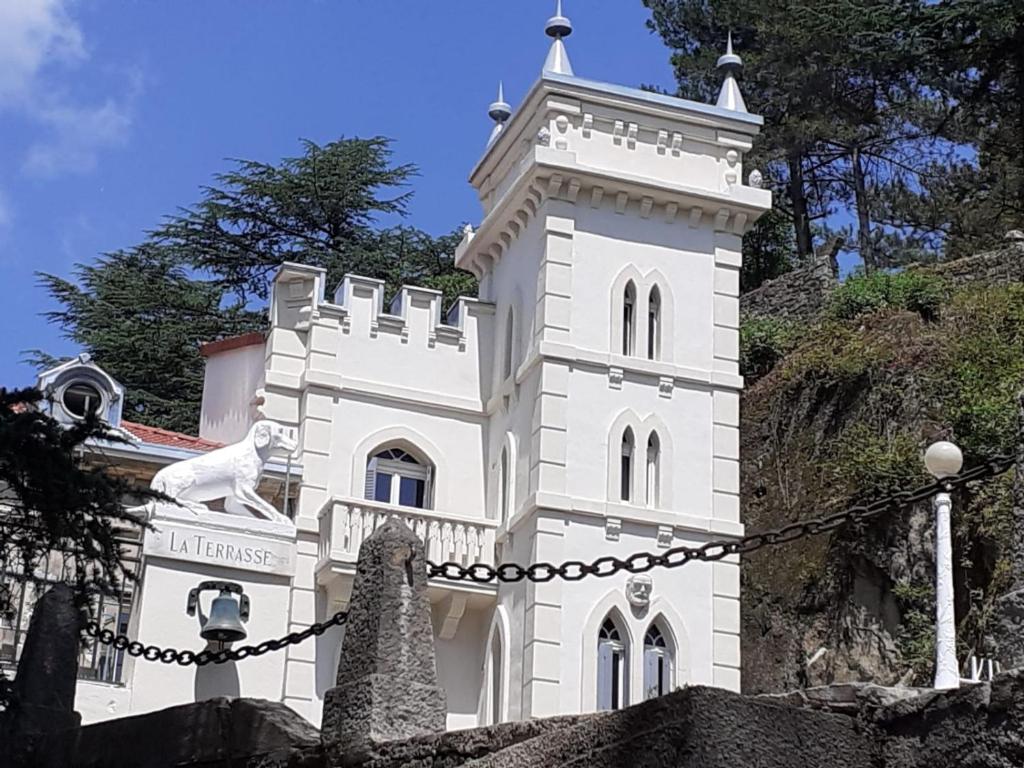 Un bâtiment blanc avec un chien en haut dans l'établissement Suite familiale Joséphine à La Terrasse 2 à 4 personnes piscine local vélos, à Tournon-sur-Rhône