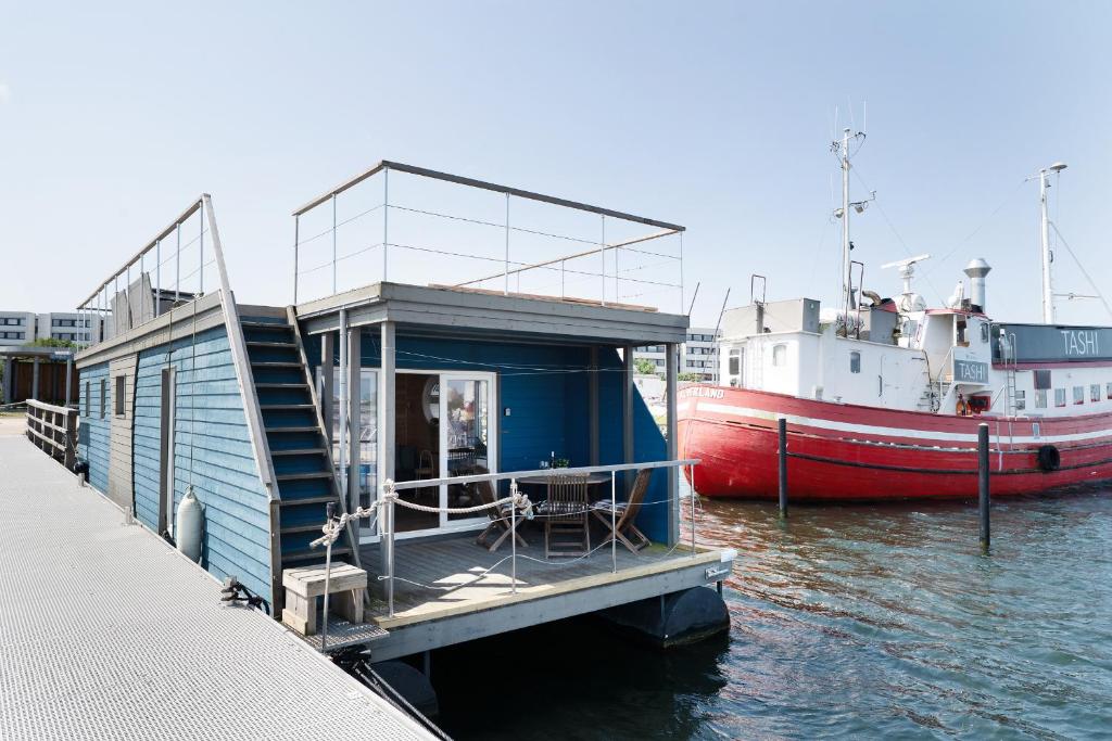 un barco está atracado junto a un edificio en el agua en Hausboot Coworkingship, en Burgtiefe auf Fehmarn 