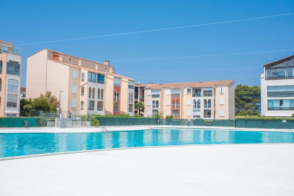 une piscine vide avec des bâtiments en arrière-plan dans l'établissement T2 Meublé 38m² loggia 6 pers maxi, à Fréjus