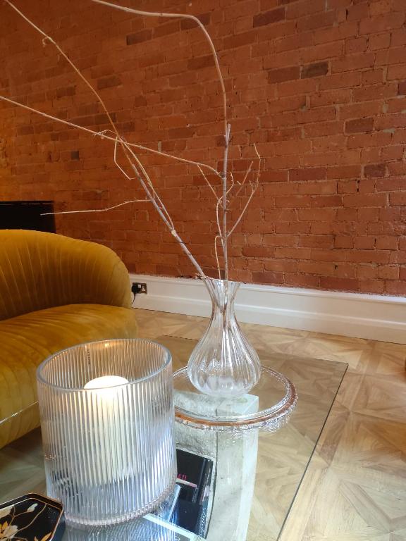 een glazen vaas op een tafel met een kaars bij Versailles in Nottingham