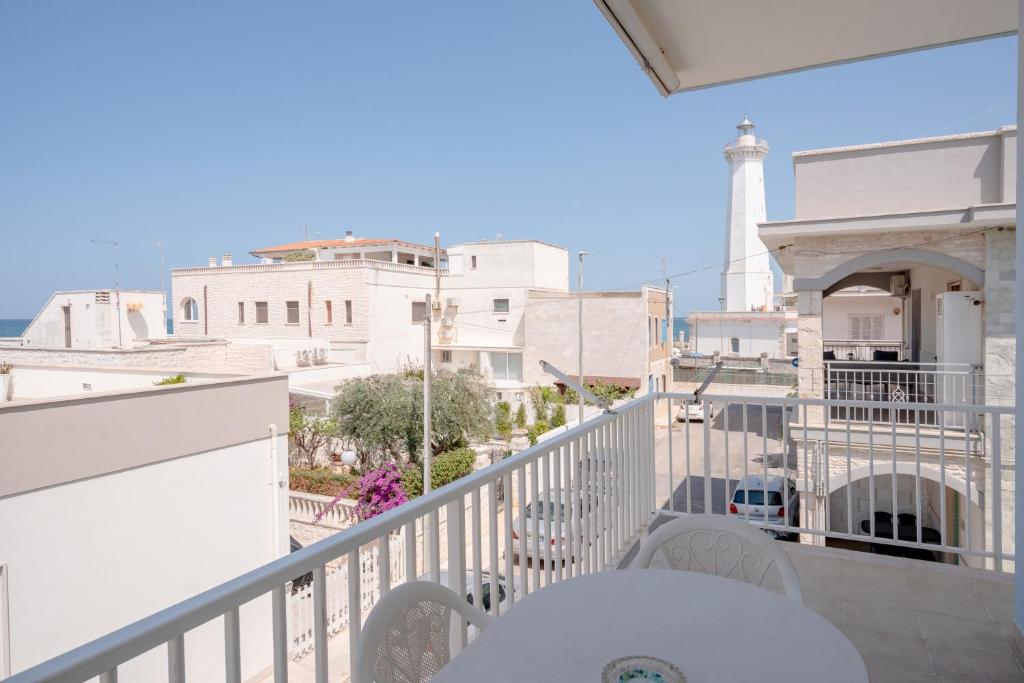 a balcony with a table and chairs and a lighthouse at Morfeo in Torre Canne
