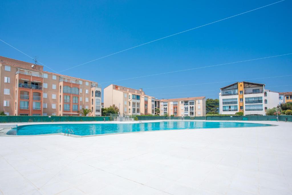 une piscine vide en face de certains bâtiments dans l'établissement Studio Meublé 25m² Piscine Et Plage, à Fréjus