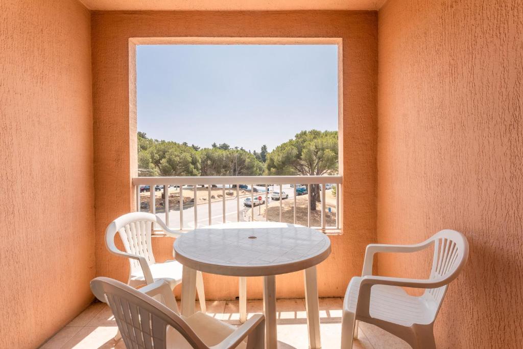 a table and chairs in a room with a window at Studio Meublé 25m² Piscine Et Plage in Fréjus