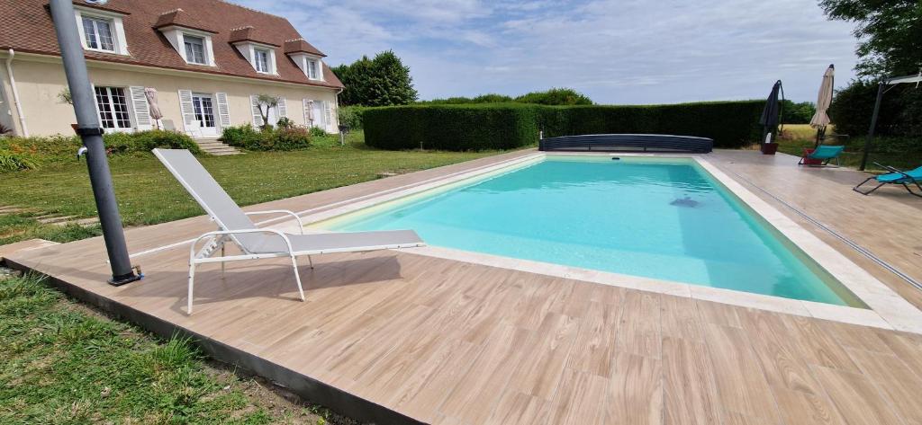 a chair sitting next to a swimming pool at Les Randonneuses in Marcilly-sur-Seine