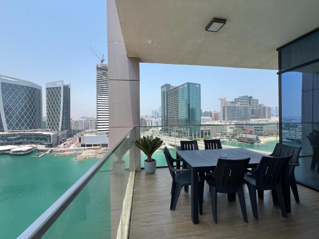 - une table à manger et des chaises sur le balcon d'un bâtiment dans l'établissement Elegant 3BDR Vista 1 Al Maryah, à Abu Dhabi