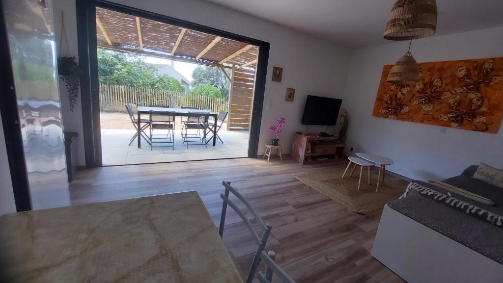 a living room with a table and a dining room at Casa corsica in Pianottoli-Caldarello