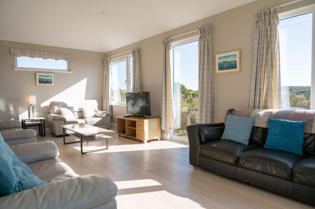 a living room with a couch and a tv at Larroch Farmhouse in Monreith