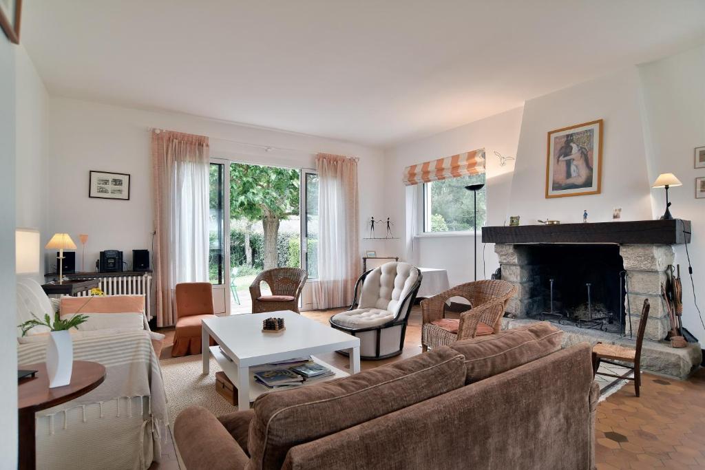 un salon avec un canapé et une cheminée dans l'établissement La Chevrière - Grande maison à 50m de la plage, à Saint-Cast-le-Guildo