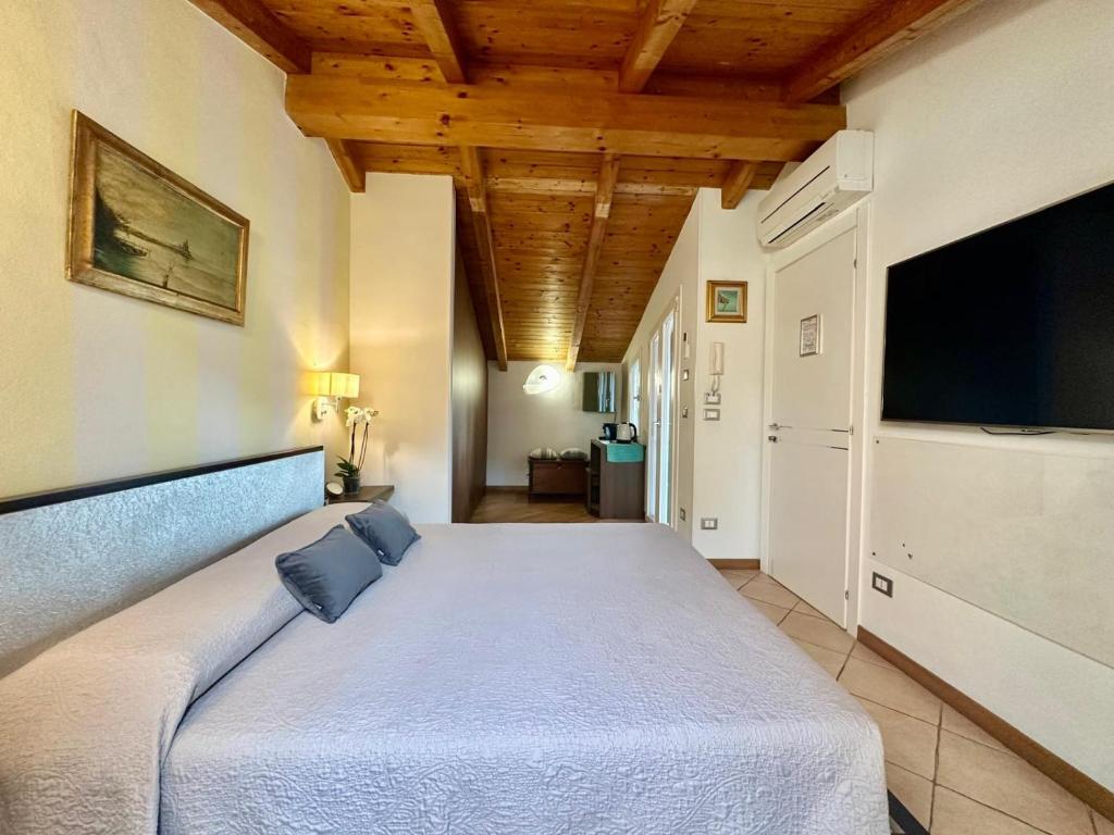 ein Schlafzimmer mit großem Bett und Flachbildfernseher in der Unterkunft La Bouganville 2 in Arma di Taggia