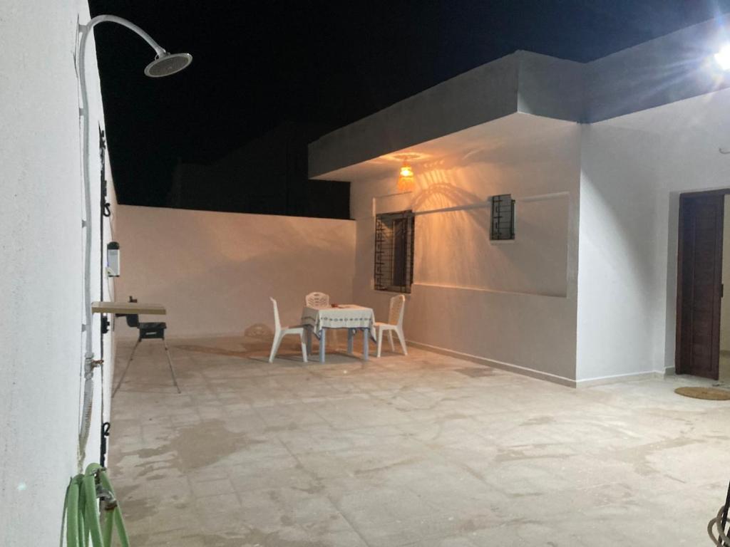 a patio with a table and chairs in a building at Maison salakta plage in Ksour Essaf