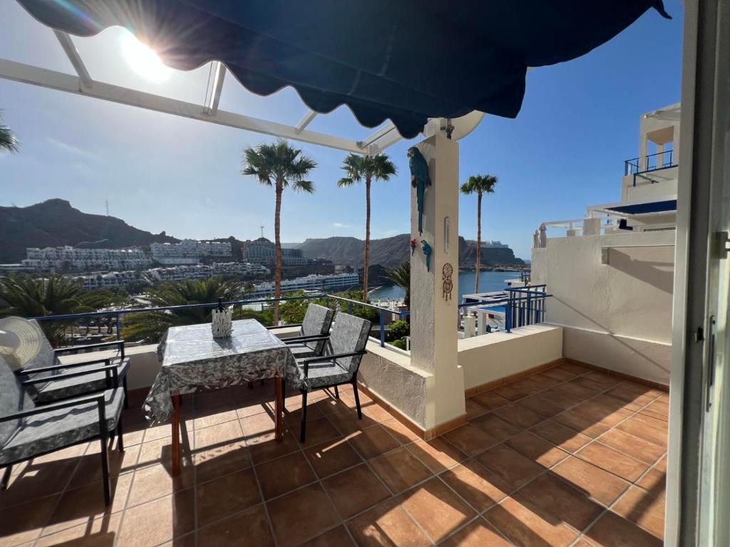 a patio with a table and chairs on a balcony at Toni LuXx Suite Monte Golf in Mogán
