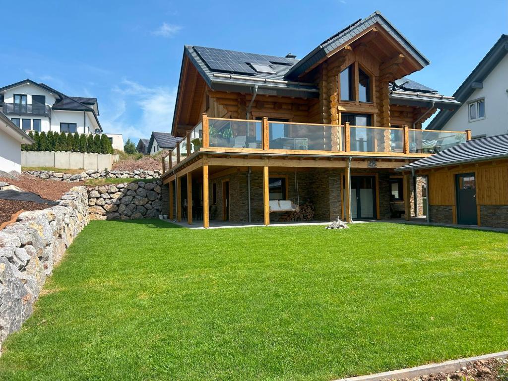 a house with a large lawn in front of it at Ferienwohnung Uplandblockhaus in Willingen