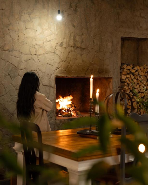 a woman sitting at a table in front of a fireplace at Boutique Guesthouse Hanover in Hanover