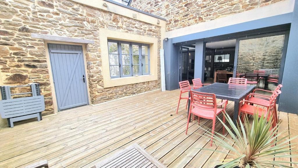 une terrasse en bois avec une table et des chaises. dans l'établissement Avelenn Belle maison de ville avec terrasse, à Concarneau