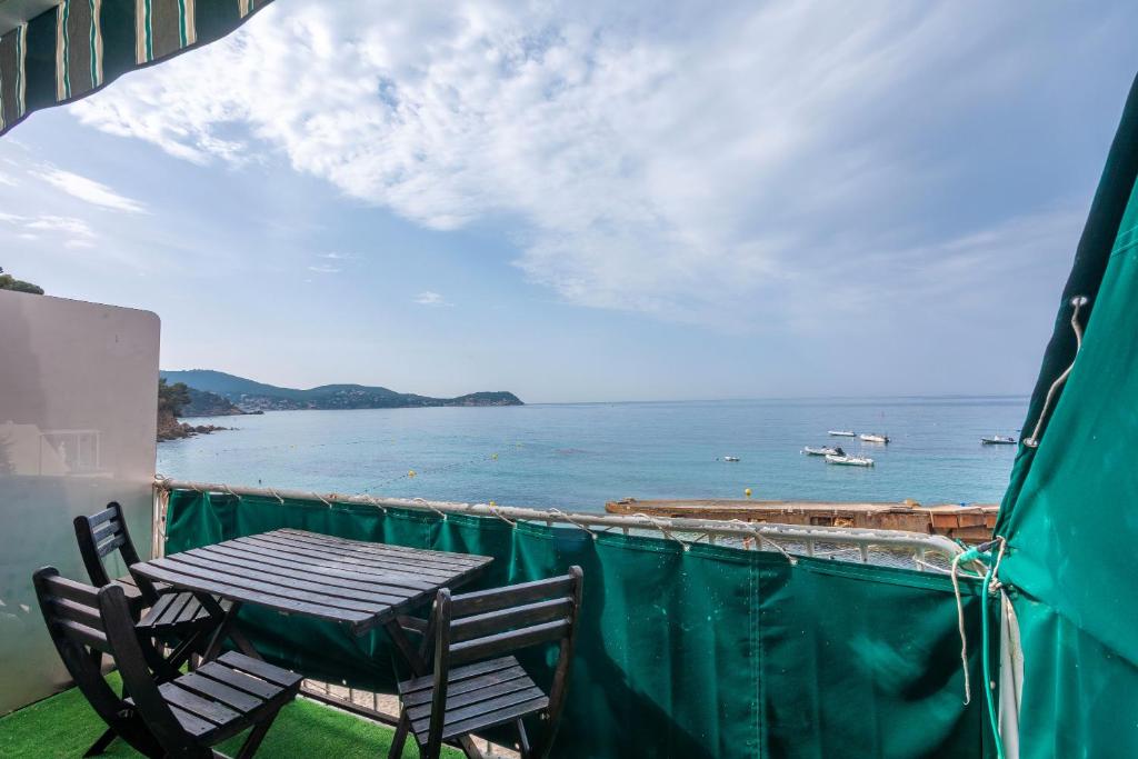 een tafel en stoelen op een balkon met uitzicht op de oceaan bij Jeux de boules 1 - T2 in Le Pradet