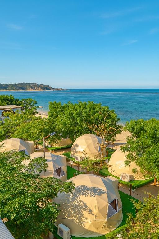 a group of tents with the ocean in the background at Vietnam Surf Camp in Ấp Mỹ Hải