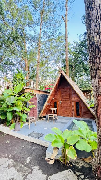 a small wooden cabin with a table and chairs at Triangle House and hot spring in Kintamani