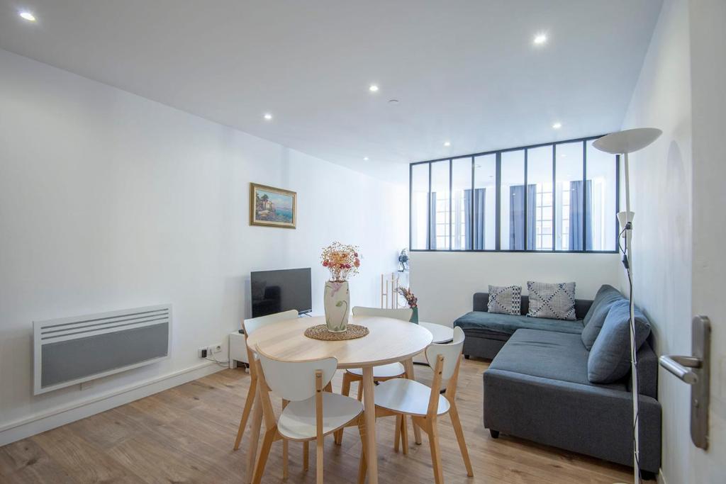 un salon avec une table et un canapé dans l'établissement Chic & Moderne 3 min Vieux-Port & Panier 4P, à Marseille